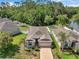 An aerial view of a single-story home with a well-manicured lawn, surrounded by lush greenery and a white picket fence at 12831 White Bluff Rd, Hudson, FL 34669