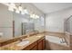 Well-lit bathroom with dual sinks, granite counters, bathtub and glass-enclosed shower at 12831 White Bluff Rd, Hudson, FL 34669
