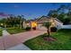 Exterior view of home at dusk featuring a well-manicured lawn, driveway, and two-car garage at 12831 White Bluff Rd, Hudson, FL 34669