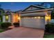 Close up of the home's garage and front entrance with exterior lighting and landscaping at 12831 White Bluff Rd, Hudson, FL 34669