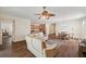 Open-concept living room with wood floors, a ceiling fan, and easy access to the kitchen and dining area at 12831 White Bluff Rd, Hudson, FL 34669