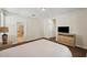 Bright main bedroom features an ensuite bathroom, wood floors, a dresser and a television at 12831 White Bluff Rd, Hudson, FL 34669