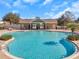 Gorgeous community pool with chairs and palm trees, surrounded by a brick-paved deck at 12831 White Bluff Rd, Hudson, FL 34669