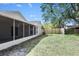 Landscaped backyard with partial view of enclosed lanai, fence, and lush trees offering a private outdoor retreat at 13613 Laraway Dr, Riverview, FL 33579