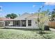 Home's backyard features green grass, a privacy fence, landscaping, and an enclosed lanai providing a private outdoor oasis at 13613 Laraway Dr, Riverview, FL 33579