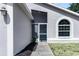 Close-up of the front entrance featuring a screen door, arched window, and manicured landscaping at 13613 Laraway Dr, Riverview, FL 33579