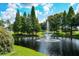 Scenic water fountain feature on a lake with manicured green grass landscape and mature trees on a sunny day at 13613 Laraway Dr, Riverview, FL 33579