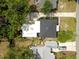 Aerial view of home showing roof, landscaping, driveway, and proximity to neighboring houses at 1443 Paloma Ln, Dunedin, FL 34698