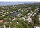 Aerial shot of neighborhood featuring a large pond surrounded by mature trees and lovely homes at 1443 Paloma Ln, Dunedin, FL 34698