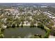 Aerial view of residential neighborhood, featuring multiple homes and a lake nestled among lush greenery at 1443 Paloma Ln, Dunedin, FL 34698