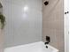 Clean bathroom features a white bathtub, gray tiled shower, and black hardware at 1443 Paloma Ln, Dunedin, FL 34698