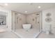 This bathroom features a soaking tub, glass enclosed shower, and modern gold fixtures at 1443 Paloma Ln, Dunedin, FL 34698