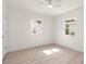 Bright bedroom with light hardwood floors, fan and two double-hung windows at 1443 Paloma Ln, Dunedin, FL 34698