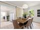 Bright dining room features barn door detail, modern light fixture, and seating for six around a wooden table at 1443 Paloma Ln, Dunedin, FL 34698