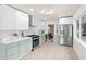 A modern kitchen features sleek, two-tone cabinetry, stainless steel appliances, and plenty of counter space for cooking at 1443 Paloma Ln, Dunedin, FL 34698