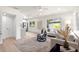 Bright living room with light wood floors, neutral furniture, and large windows that flood the space with natural light at 1443 Paloma Ln, Dunedin, FL 34698