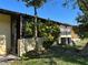 Private backyard with a lush lawn, mature trees, and an air conditioning unit at 1503 12Th Se Ct # 1503, Largo, FL 33771