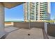 Spacious brick balcony with ocean views and a tall building in the background at 1560 Gulf Blvd # 306, Clearwater Beach, FL 33767