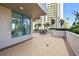 View of patio featuring brick pavers and a serene ocean backdrop with palm trees at 1560 Gulf Blvd # 306, Clearwater Beach, FL 33767