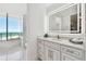 Bright bathroom featuring a vanity with storage and a large mirror, plus ocean views at 1560 Gulf Blvd # 306, Clearwater Beach, FL 33767