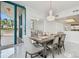 Elegant dining room with chandelier lighting and access to a balcony and modern kitchen at 1560 Gulf Blvd # 306, Clearwater Beach, FL 33767
