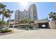 Luxury condo building with lush landscaping, a covered entrance, and an ocean view, located near the beach at 1560 Gulf Blvd # 306, Clearwater Beach, FL 33767