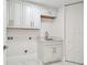 Bright laundry room with white cabinets, marble floors, a countertop, and a sink at 1560 Gulf Blvd # 306, Clearwater Beach, FL 33767