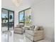Cozy sitting area with plush chairs and large windows offering views of palm trees and the outdoors at 1560 Gulf Blvd # 306, Clearwater Beach, FL 33767