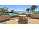 Enjoy ocean views from this outdoor patio that includes a table set, pool, palm trees and beautiful turquoise water at 1560 Gulf Blvd # 306, Clearwater Beach, FL 33767
