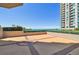 A patio with brick tile shows an ocean view and a large condo building at 1560 Gulf Blvd # 306, Clearwater Beach, FL 33767