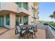 A covered patio with brick tile and table and chairs showcases ocean views at 1560 Gulf Blvd # 306, Clearwater Beach, FL 33767