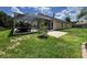 View of the home's backyard with screened-in pool area, brick patio, and lush lawn and privacy fence at 18002 Kings Park Dr, Tampa, FL 33647