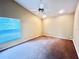 A cozy bedroom featuring a ceiling fan, plush carpeting, and a brightly lit window at 18002 Kings Park Dr, Tampa, FL 33647