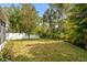 The backyard has a spacious lawn, mature trees, and a white privacy fence at 19101 Marisa Ridge Pl, Tampa, FL 33647
