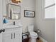 Bright half-bathroom with white vanity, black fixtures, and framed mirror at 19101 Marisa Ridge Pl, Tampa, FL 33647