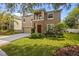 Two-story tan house with a stone pillar front porch, attached garage, and landscaped yard at 19101 Marisa Ridge Pl, Tampa, FL 33647