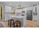 Bright kitchen features white cabinets, stainless appliances, and a large center island with seating at 19101 Marisa Ridge Pl, Tampa, FL 33647