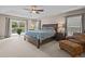 Spacious main bedroom featuring a tray ceiling, ensuite bathroom, and a private balcony overlooking the yard at 19101 Marisa Ridge Pl, Tampa, FL 33647