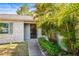 Close-up of the front entrance with lush tropical landscaping at 1913 Peppertree Dr, Oldsmar, FL 34677