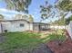 Back exterior features a covered patio, flowering tree, and fenced yard at 2001 Pinellas Point S Dr, St Petersburg, FL 33712