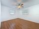 Cozy bedroom with wood-look floors, ceiling fan, and natural light from two windows at 2001 Pinellas Point S Dr, St Petersburg, FL 33712