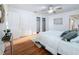 Well-lit bedroom showcases hardwood floors, white bedding, and multiple closets at 2001 Pinellas Point S Dr, St Petersburg, FL 33712