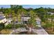 Landscaped single-story home featuring a well-manicured lawn, brick driveway, mature trees, and an attached two-car garage at 2001 Pinellas Point S Dr, St Petersburg, FL 33712