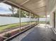 Enclosed patio overlooks a fenced backyard with mature trees and landscaping at 2001 Pinellas Point S Dr, St Petersburg, FL 33712