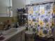 Functional bathroom features a vanity, a toilet, and a shower with a bright, floral patterned curtain at 2071 Australia W Way # 59, Clearwater, FL 33763