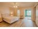 Sunlit bedroom featuring laminate flooring, a slider door, and access to the en suite bathroom at 2071 Australia W Way # 59, Clearwater, FL 33763