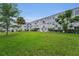Exterior view of building with manicured lawn and mature landscaping at 2460 Persian Dr # 54, Clearwater, FL 33763