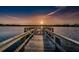 Wooden dock extending into the lake with colorful sunset views, providing direct water access at 2460 Persian Dr # 54, Clearwater, FL 33763