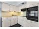 Bright kitchen with white cabinets, and a built-in oven at 2460 Persian Dr # 54, Clearwater, FL 33763