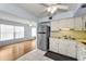 Bright kitchen featuring white cabinets, stainless steel refrigerator, and views to the living area at 2460 Persian Dr # 54, Clearwater, FL 33763